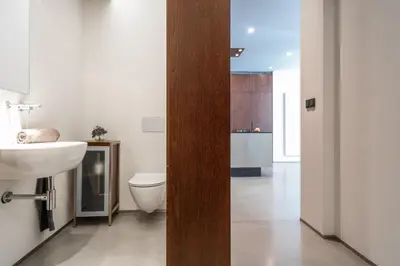 a bathroom with a white toilet and a sink at The Grand Krocínova Loft - Golden Bond Retreat in Prague