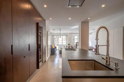 a kitchen with a sink and a living room at The Grand Krocínova Loft - Golden Bond Retreat in Prague