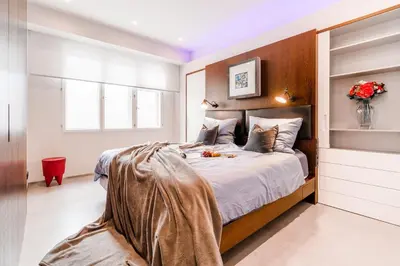 a bedroom with a large bed with a wooden headboard at The Grand Krocínova Loft - Golden Bond Retreat in Prague