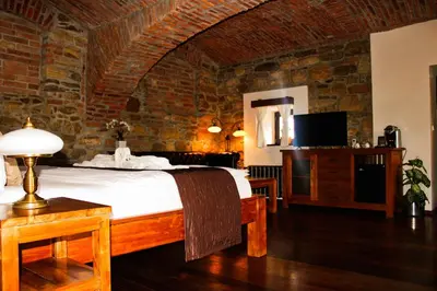 a bedroom with a bed and a brick wall at Pension U Hastrmana in Prague