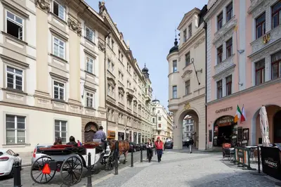a horse drawn carriage on a city street with buildings at OLD TOWN - 4 Room 2 Bathroom Apartment in Prague