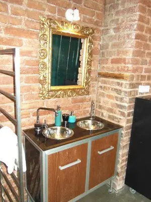 a bathroom with two sinks and a mirror on a brick wall at OLD TOWN - 4 Room 2 Bathroom Apartment in Prague