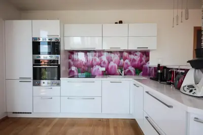 a white kitchen with pink flowers on the wall at Cosy and spacious apartment with the view to the garden in Prague