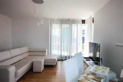 a living room with a white couch and a tv at Cosy and spacious apartment with the view to the garden in Prague