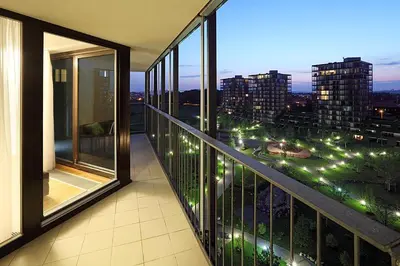 a balcony with a view of a city at night at Cosy and spacious apartment with the view to the garden in Prague