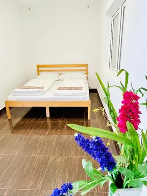 a bed in a room with flowers in the foreground at Villa Apartments with Free Parking Prague 5 in Prague