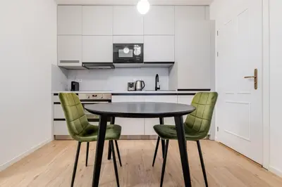a kitchen with a black table and green chairs at Blueground Prague 2 furnished Náměstí Míru PRG-44 in Prague