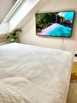a bedroom with a tv hanging on the wall at Luxury New Apartment with Balcony Steps from Wenceslas Square in Prague
