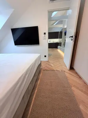 a bedroom with a large bed and a flat screen tv at Luxury New Apartment with Balcony Steps from Wenceslas Square in Prague
