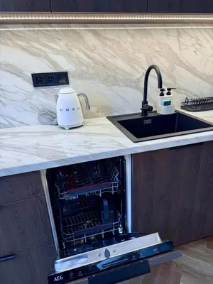 an open dishwasher in a kitchen with a sink at Luxury New Apartment with Balcony Steps from Wenceslas Square in Prague