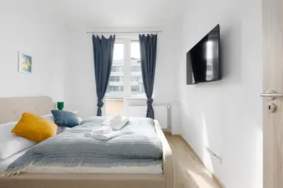 a bedroom with a bed and a tv and a window at 2 bedroom apartment with a terrace near the metro in Prague