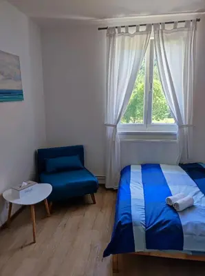 a bedroom with a bed and a chair and a window at Lávka 222 in Chocerady