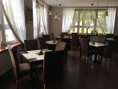 a dining room with tables and chairs and windows at Lávka 222 in Chocerady