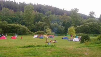 a group of people in a field with tents at Lávka 222 in Chocerady