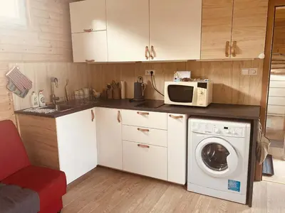 a kitchen with a washing machine and a microwave at Domeček Pikovice in Píkovice