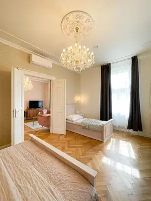 a bedroom with a bed and a chandelier at Stupartska Grand Residence in Prague