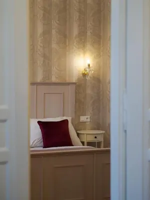 a bedroom with a bed with a red pillow on it at Stupartska Grand Residence in Prague