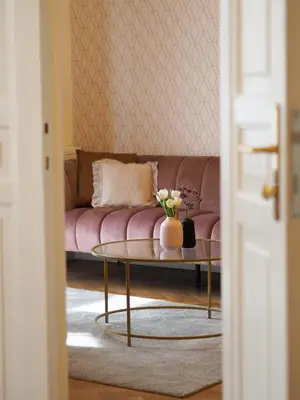 a living room with a pink couch and a table at Stupartska Grand Residence in Prague