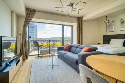 a living room with a couch and a tv and a bed at Czech TESLA apartment by Rentez in Prague