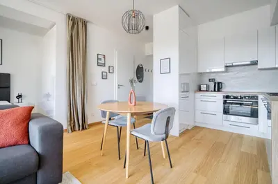 a kitchen and living room with a table and chairs at Czech TESLA apartment by Rentez in Prague
