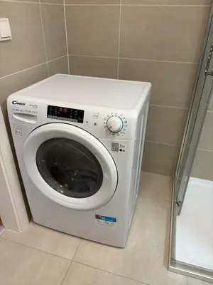 a washing machine in a bathroom next to a shower at Czech TESLA apartment by Rentez in Prague