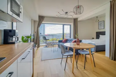 a kitchen and living room with a bed and a table at Czech TESLA apartment by Rentez in Prague