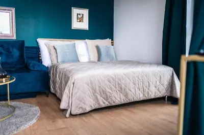a bedroom with a bed and a blue wall at WagnerStays Modern Suites Residence in Prague