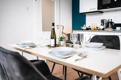 a white table with glasses and a bottle of wine at WagnerStays Modern Suites Residence in Prague
