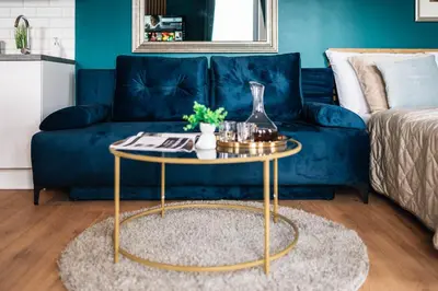 a blue couch with a coffee table in a living room at WagnerStays Modern Suites Residence in Prague