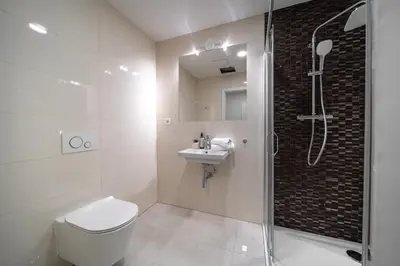 a bathroom with a shower and a toilet and a sink at WagnerStays Modern Suites Residence in Prague