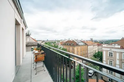 a balcony with a desk and a view of the city at WagnerStays Modern Suites Residence in Prague