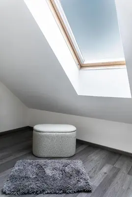 a room with a ottoman in front of a window at The Loft Holešovice in Prague