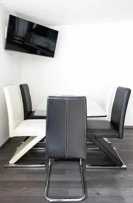 a dining room table with two chairs and a tv at The Loft Holešovice in Prague