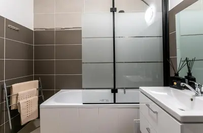a bathroom with a white tub and a sink at The Loft Holešovice in Prague