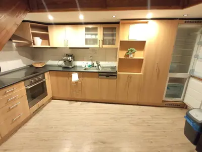 a large kitchen with wooden cabinets and appliances at CozyGem House 2