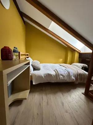 a bedroom with a bed and a desk and a window at CozyGem House 2
