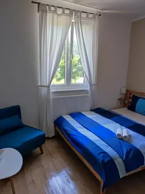 a bedroom with a blue bed and a window at Lávka 222 Chocerady in Chocerady