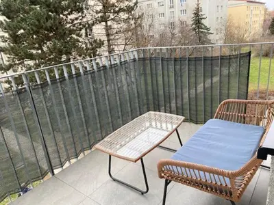 a patio with two chairs and a table and a fence at NEW apartment in Prague in Prague