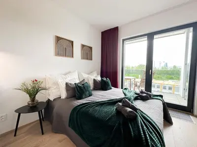 a bedroom with a large bed and a large window at REAL Living by REFA Balcony Retreat 75 in Prague