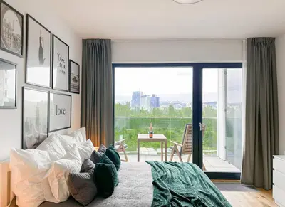 a bedroom with a bed with a view of a balcony at REAL Living by REFA Balcony Retreat 75 in Prague