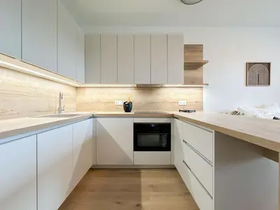 a kitchen with white cabinets and a sink at REAL Living by REFA Balcony Retreat 75 in Prague