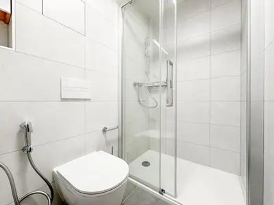 a white bathroom with a shower and a toilet at REAL Living by REFA Balcony Retreat 75 in Prague