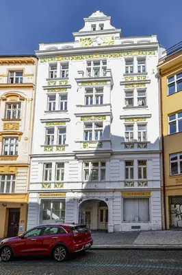 a red car parked in front of a white building at Main Square Quite Air Conditioned Apartment in Prague