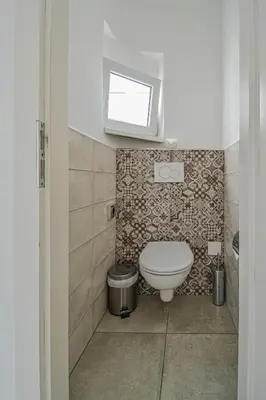 a bathroom with a toilet and a television on the wall at Main Square Quite Air Conditioned Apartment in Prague