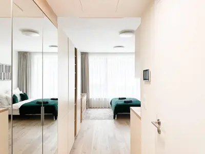 a bedroom with two beds and a mirror at REAL Living by REFA Karlin 406 in Prague
