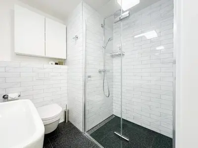 a bathroom with a toilet and a glass shower at REAL Living by REFA Karlin 406 in Prague
