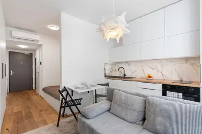 a living room with a couch and a kitchen at REAL Living by REFA Karlin 305 in Prague