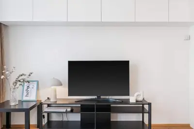 a television on a black stand in a living room at REAL Living by REFA Karlin 305 in Prague