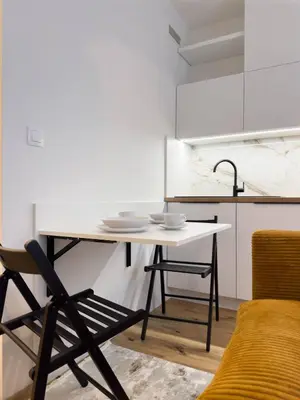 a table and a chair in a kitchen at REAL Living by REFA Karlin 208 in Prague