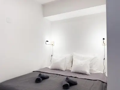 a bed with two pairs of shoes sitting on it at REAL Living by REFA Karlin 208 in Prague